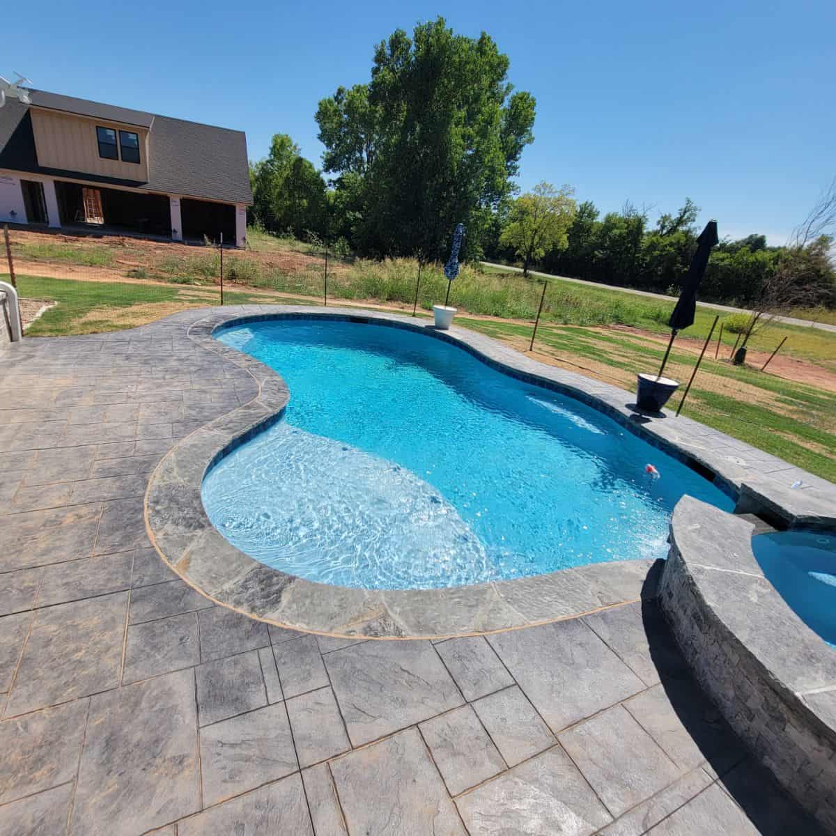 80 ft perimeter pool and spa with stamped concrete in Guthrie.